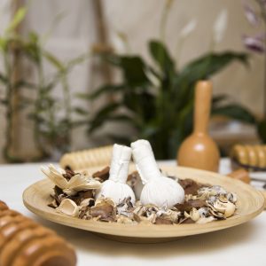 Aromatic herbal massage bags with herbs in the wooden plate and wooden maderotherapy tool